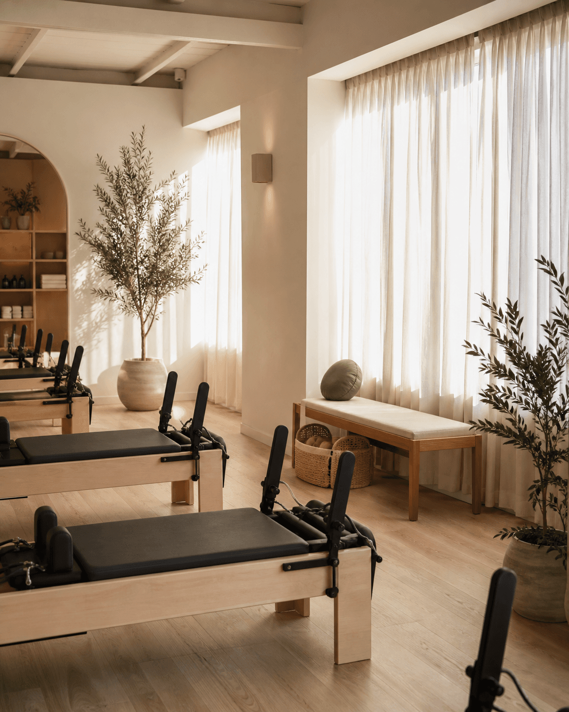 Warm boutique Pilates studio with reformer equipment and natural light